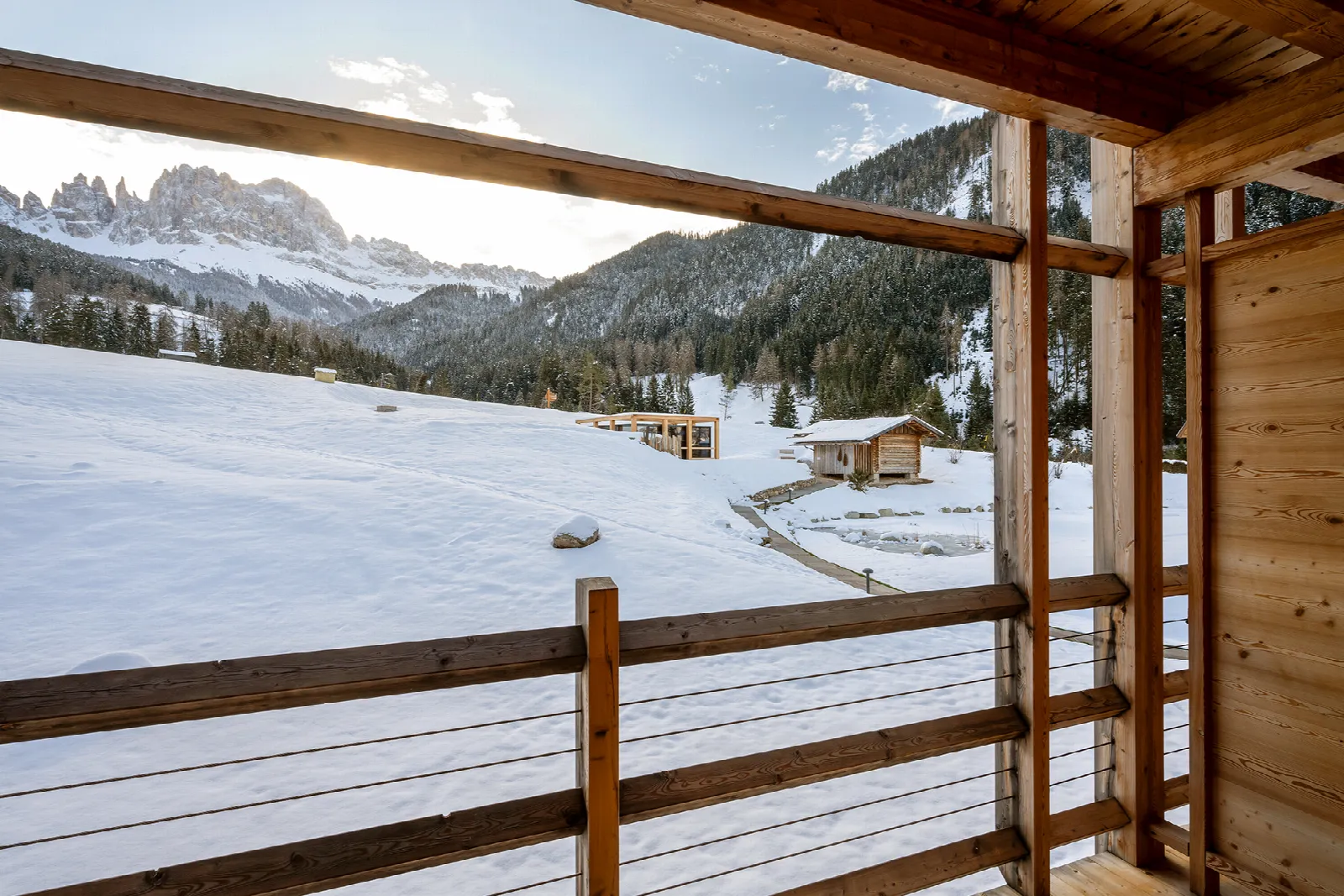 Winterlicher Balkonblick vom Delago Zimmer auf verschneite Landschaft und Dolomiten im Cyprianerhof